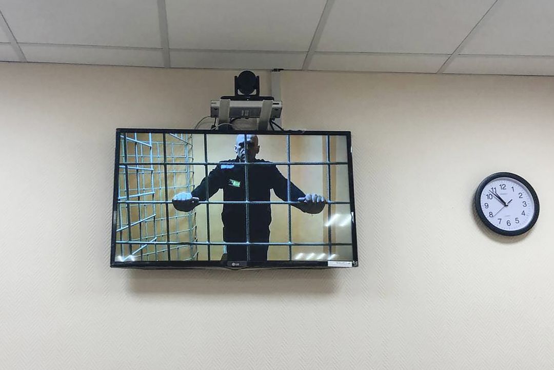 Televisio, jossa näkyy Aleksei Navalnyi vankilan häkissä.