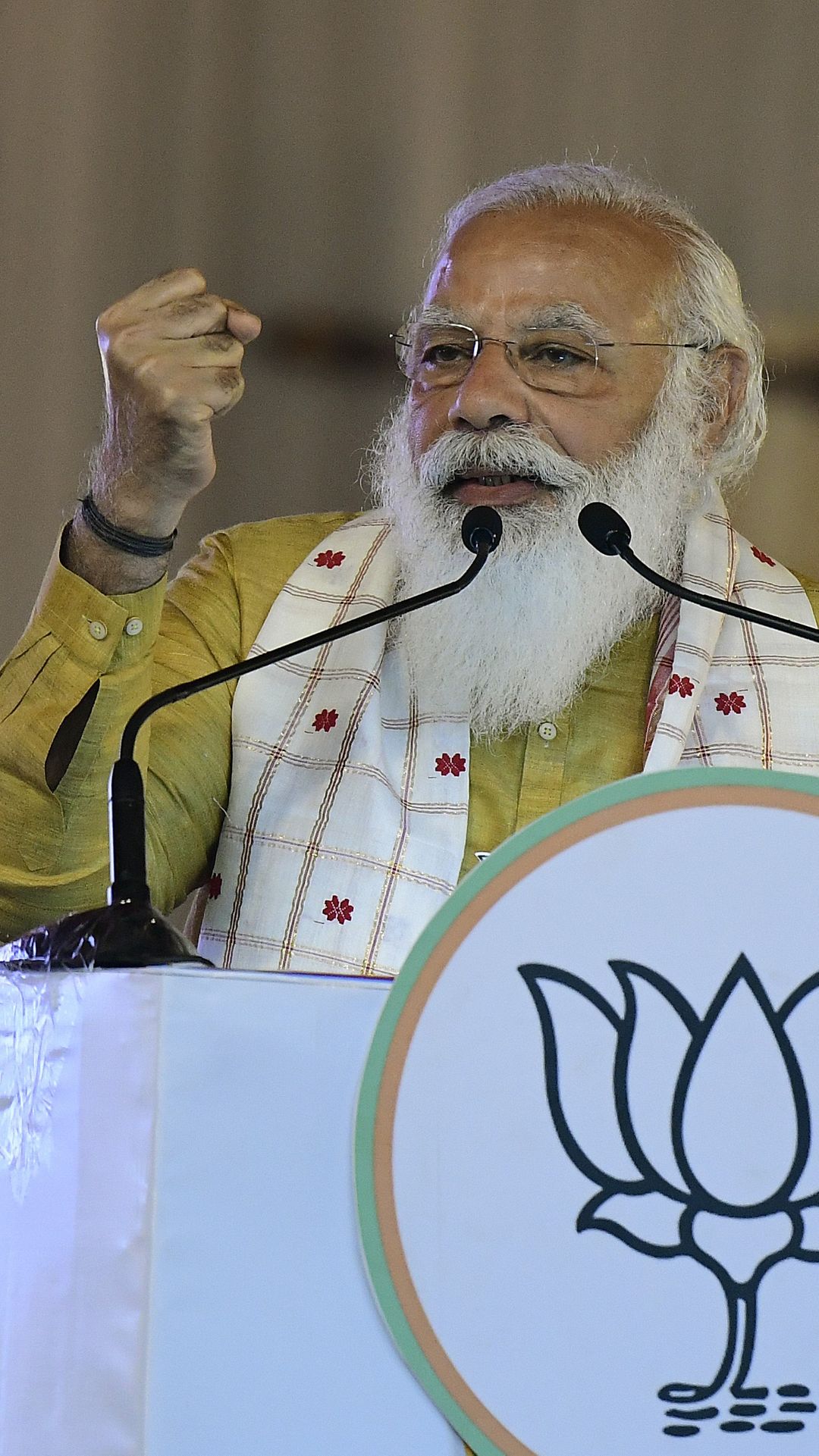 Nyrkkiään heristävä Narendra Modi lähikuvassa puhujanpöntössä.