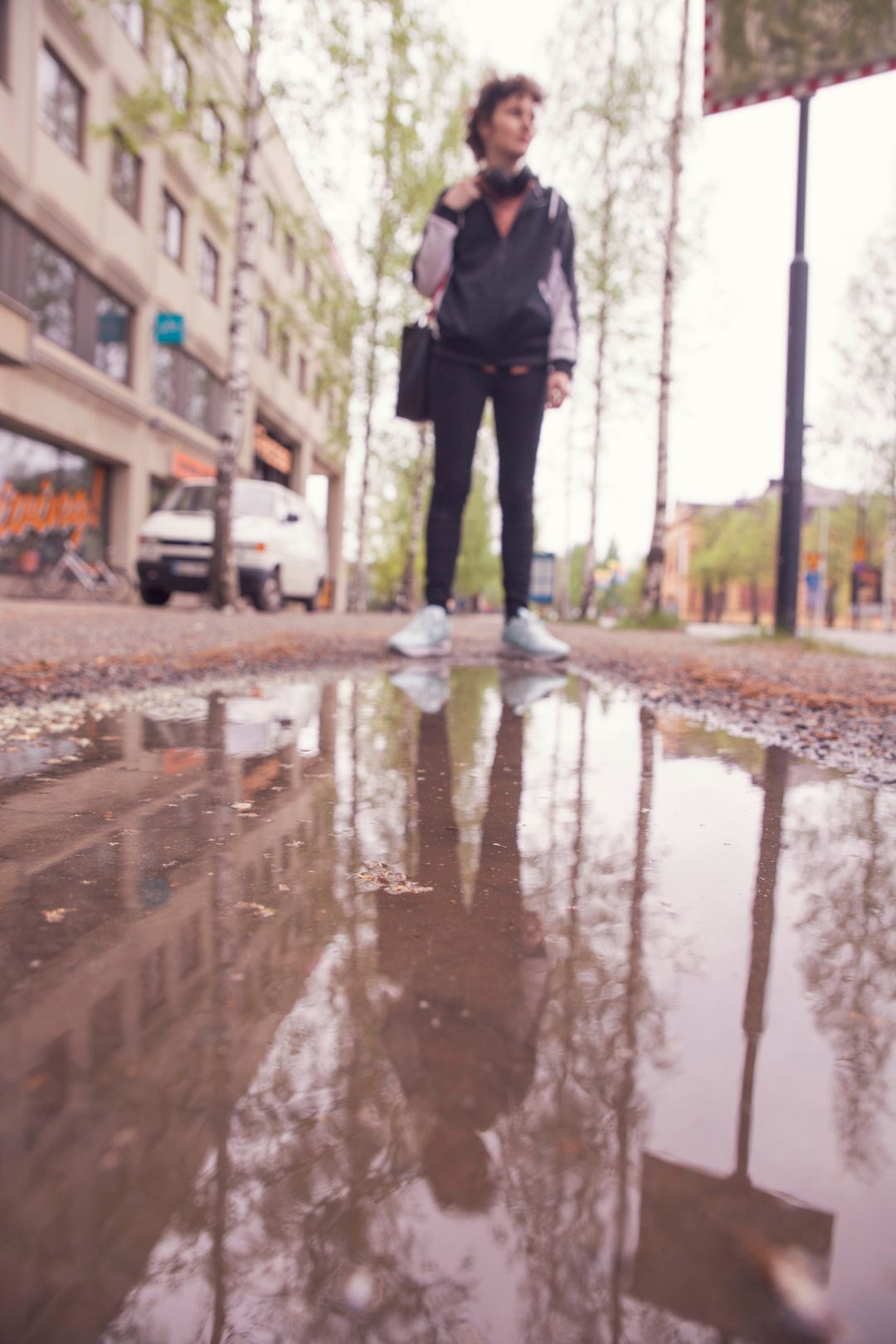 Nainen seisoo vesilätäkön edessä.