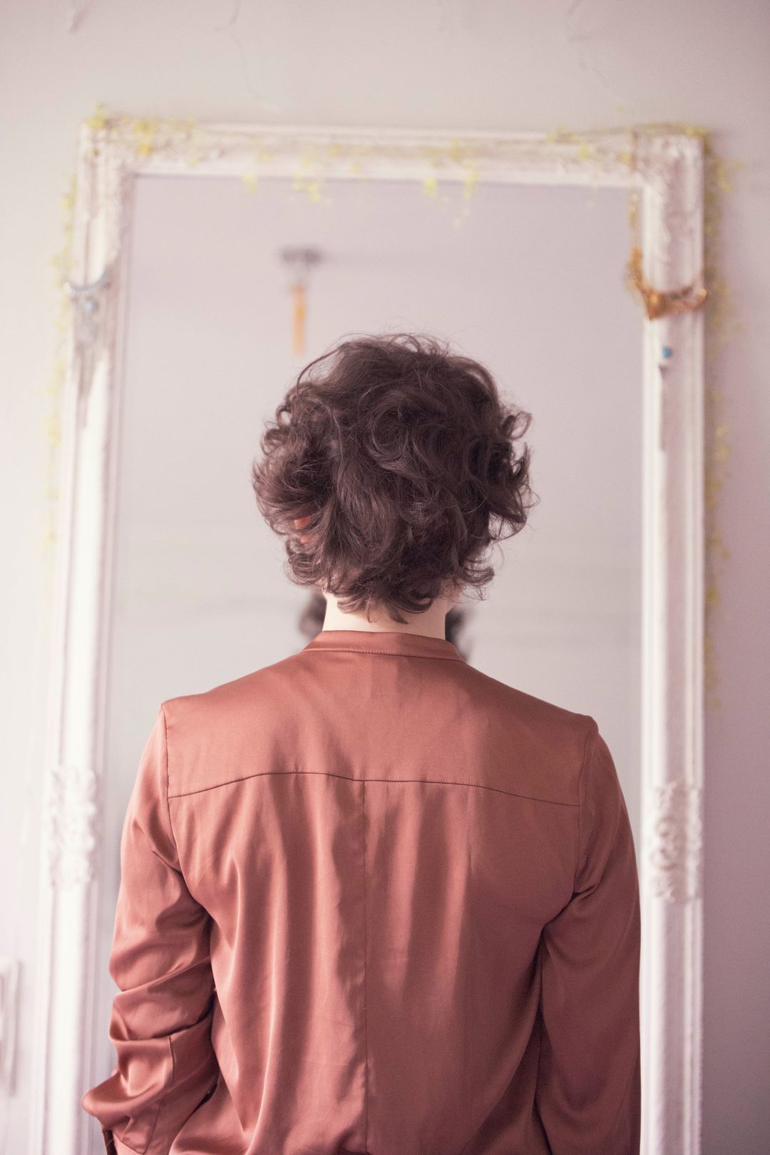 Nainen katsoo peiliin.