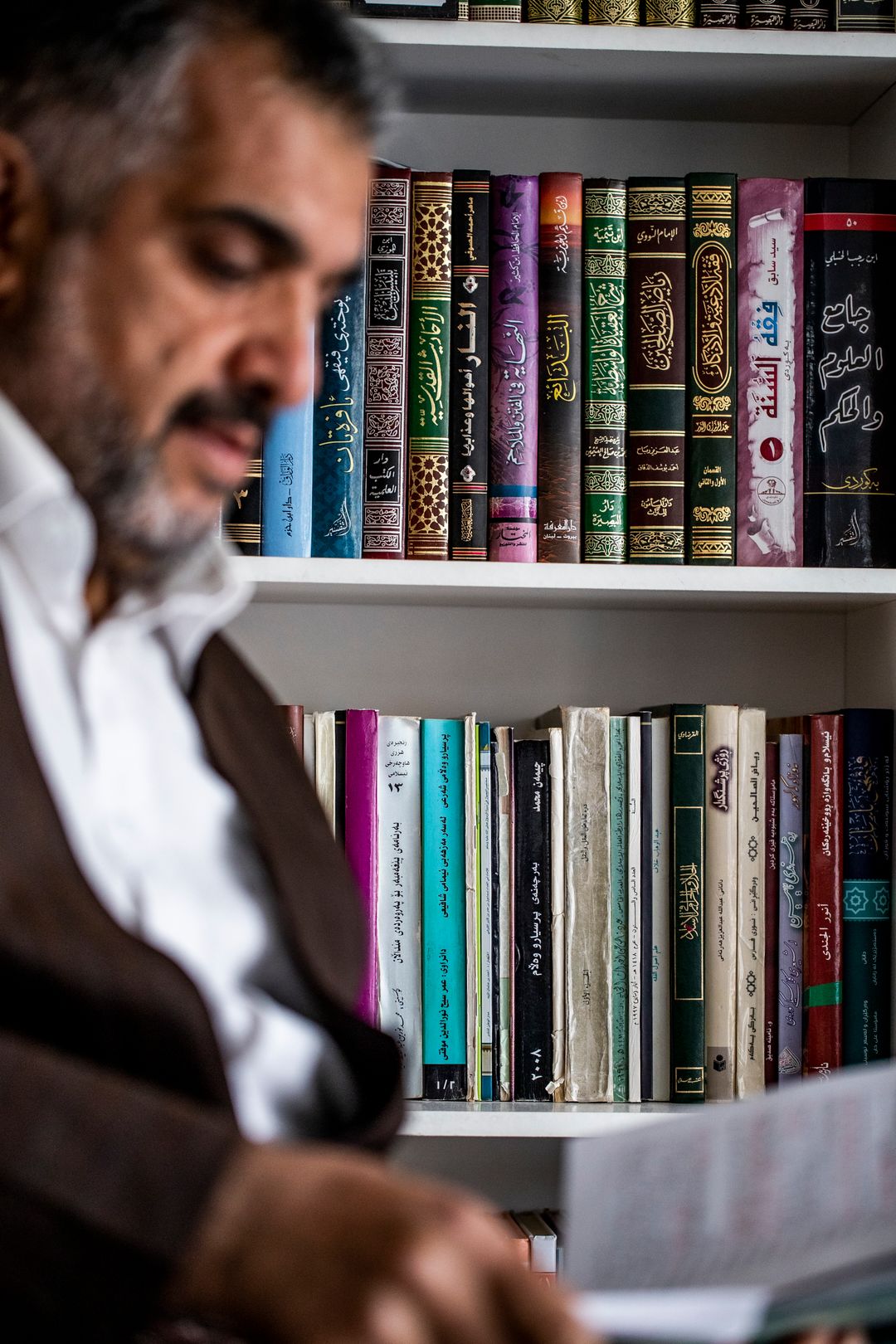 Imaami Saber Sorani lukee kirjaa.