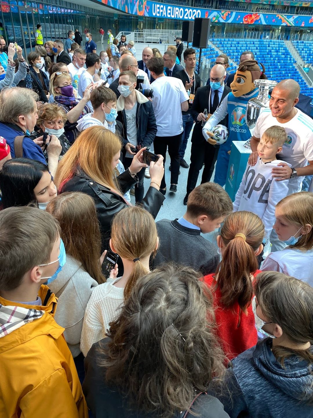 Väentungos, jossa maskittomat nuoret ympäröivät David Trezegueta stadionilla.