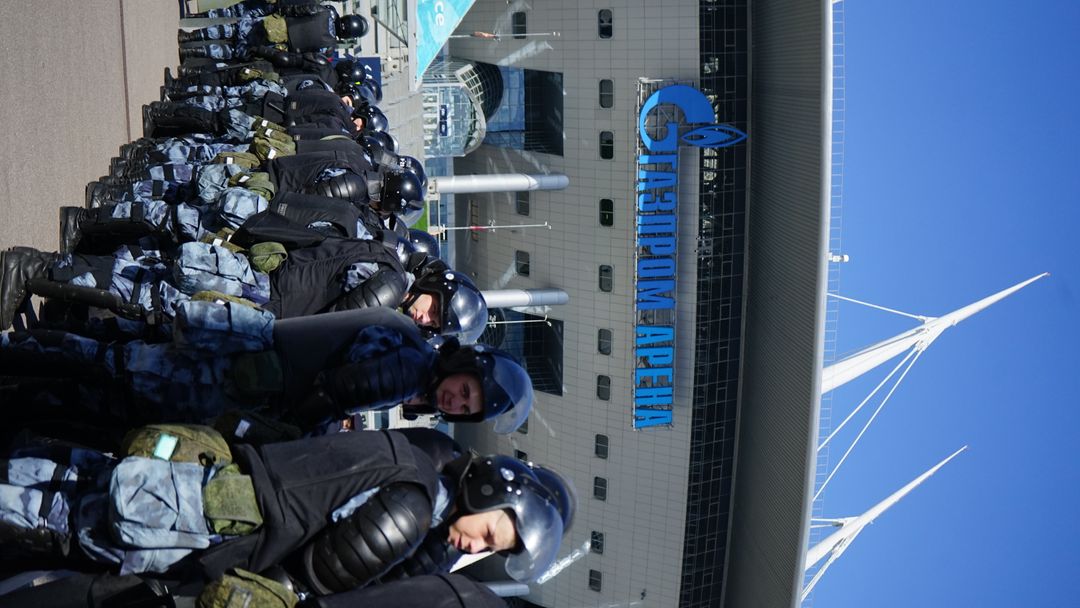 Etualalla mellakkavarusteisia poliiseja, taustalla Pietarin stadion.