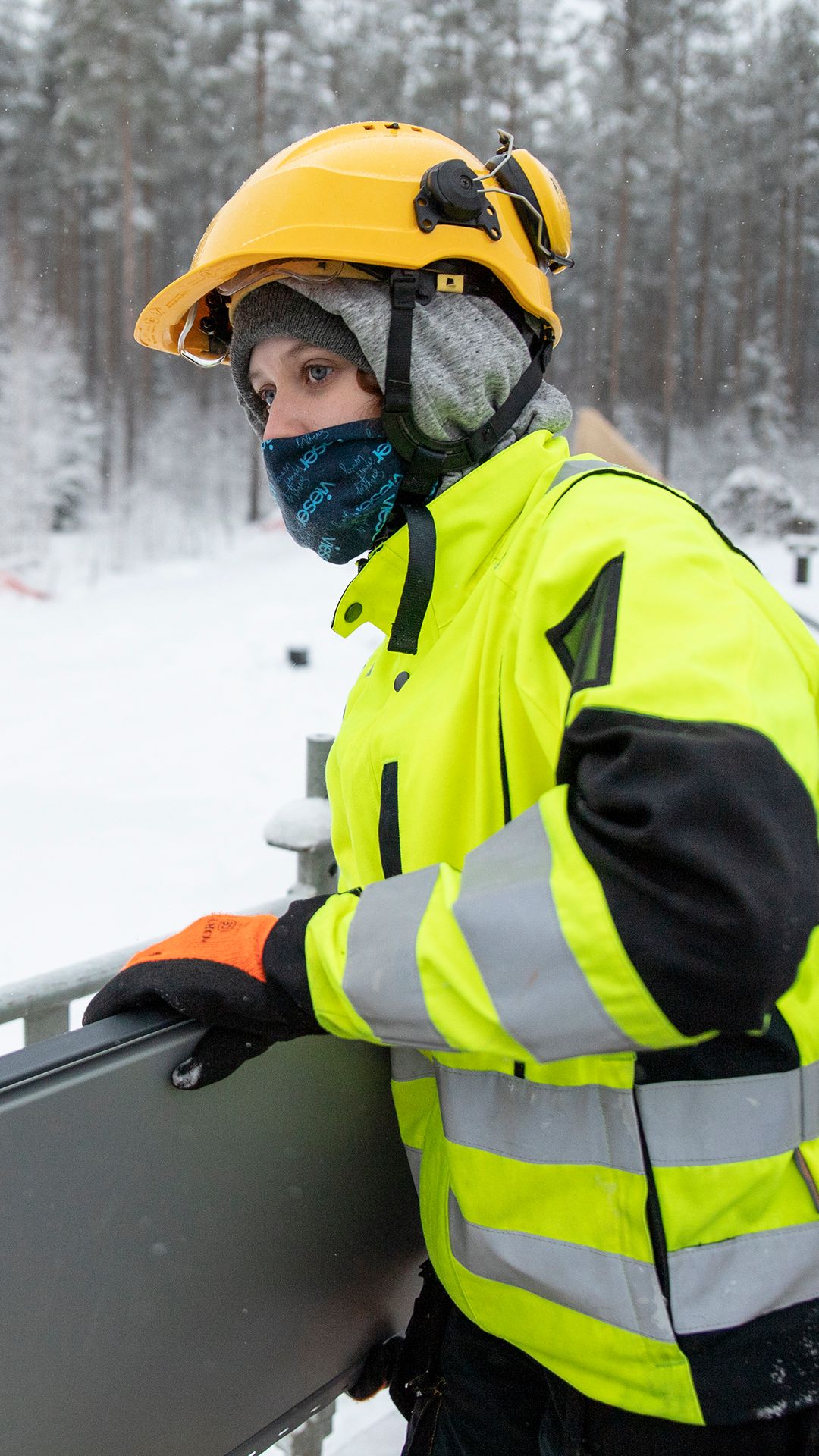 Henna Randell kantaa kattopeltiä rakennustyömaalla