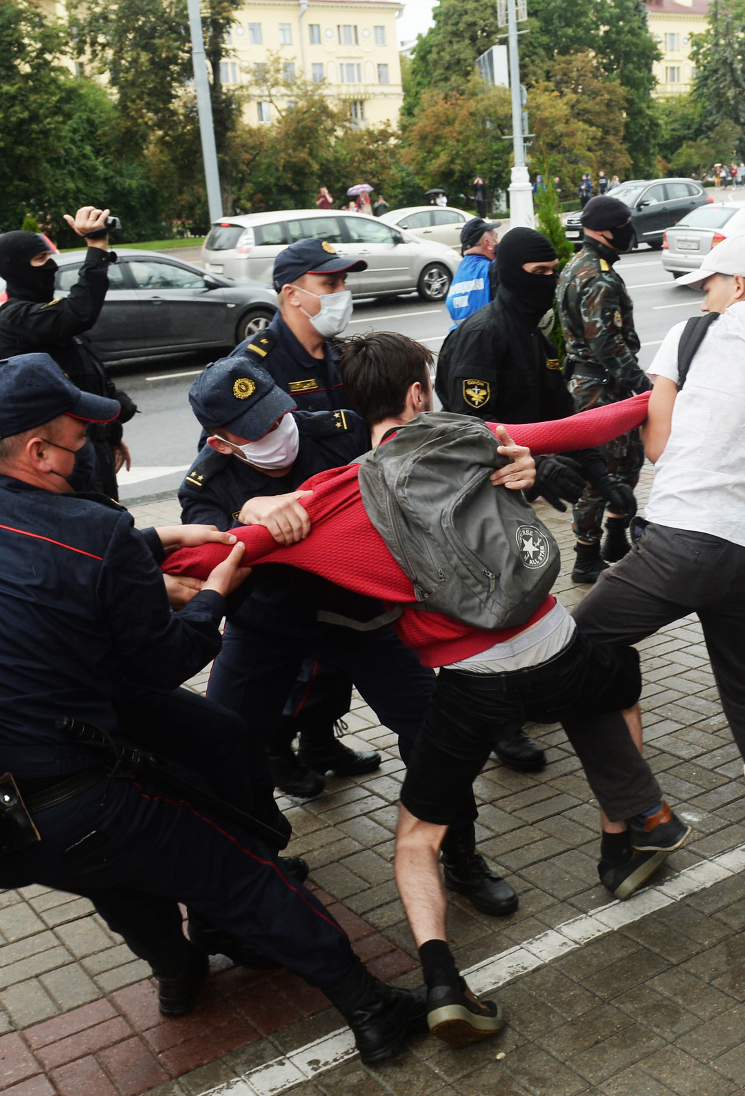 Poliisit retuuttavat opiskelijamiestä.