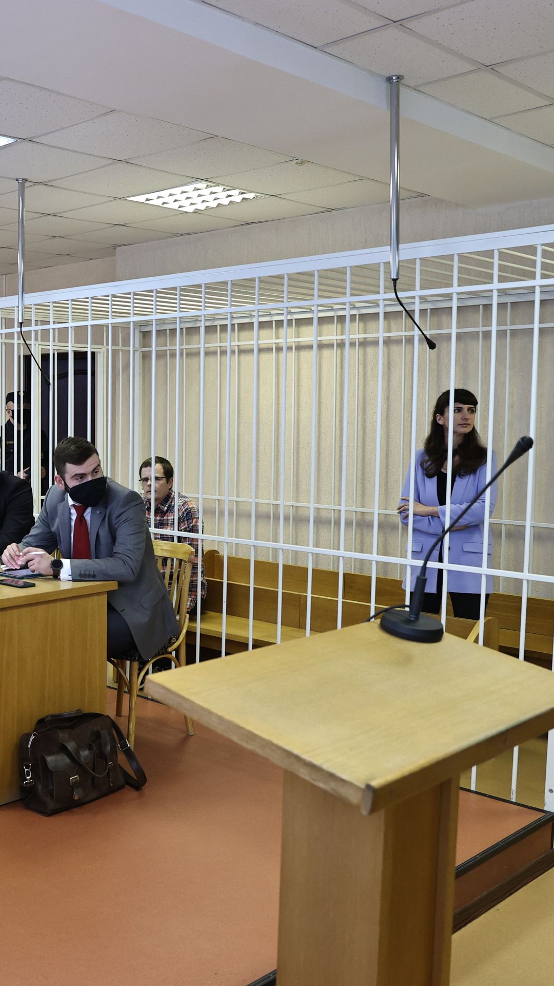 Toimittaja häkissä oikeussalissa.