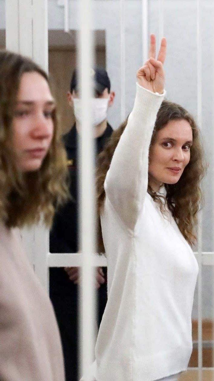 Vangittu toimittaja näyttää voitonmerkkiä.